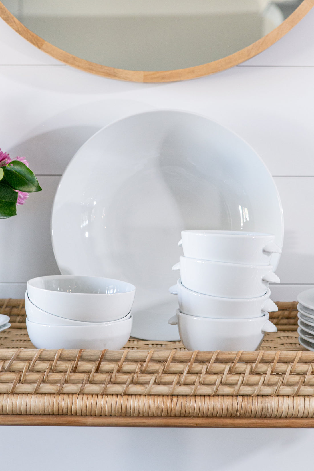 White ceramic dinnerware including a large platter, ramekins, and bowls styled on a rattan tray for a spring kitchen refresh