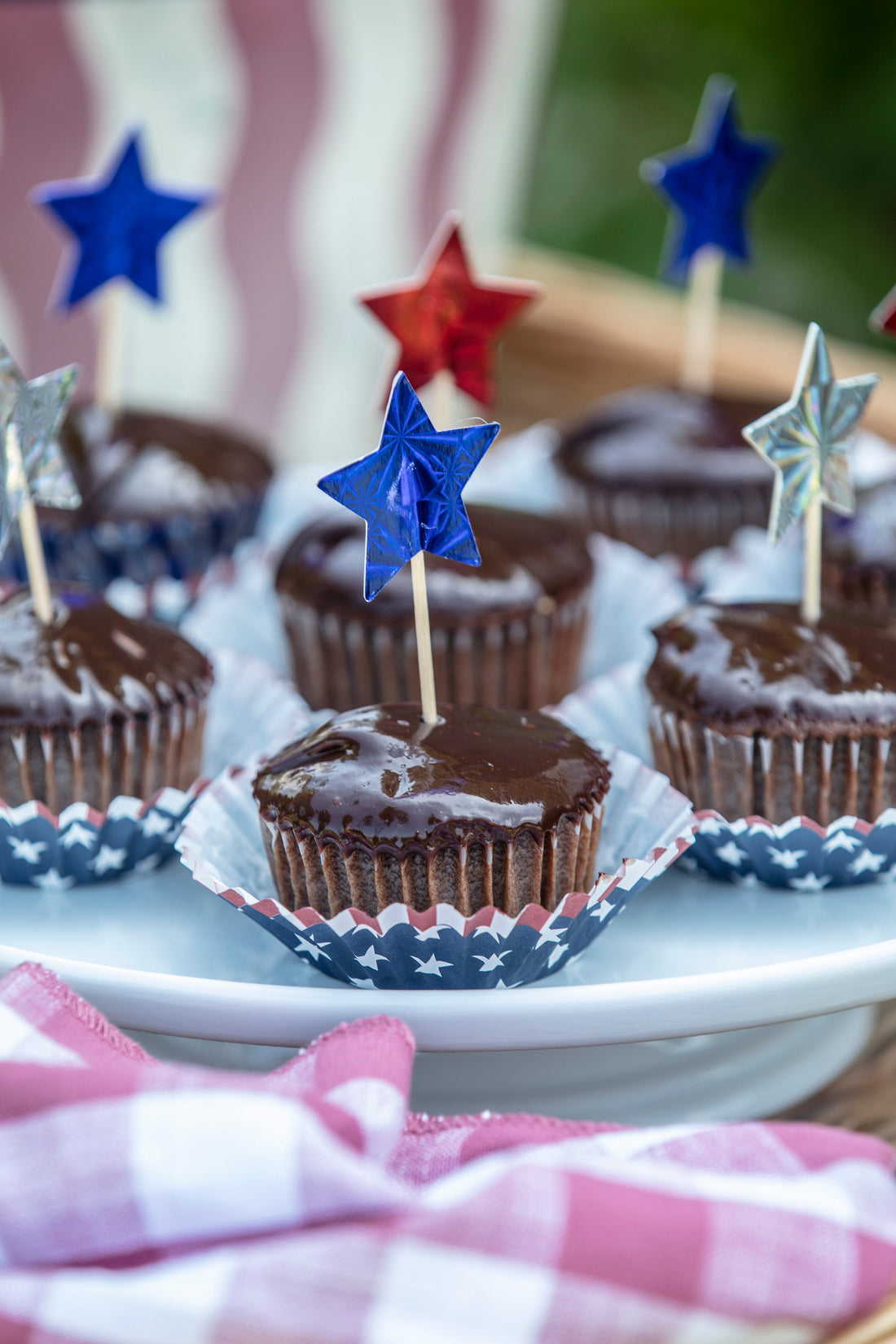 Ina Garten's Chocolate Ganache Cupcakes with patriotic star picks in red, white, and blue cupcake liners
