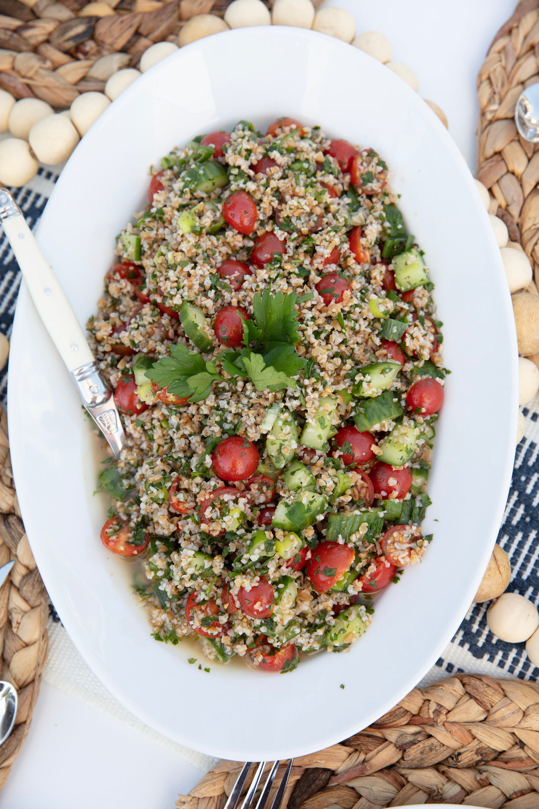 Tabouleh and tzatziki spread at an outdoor lakeside party with fresh pita and vegetables