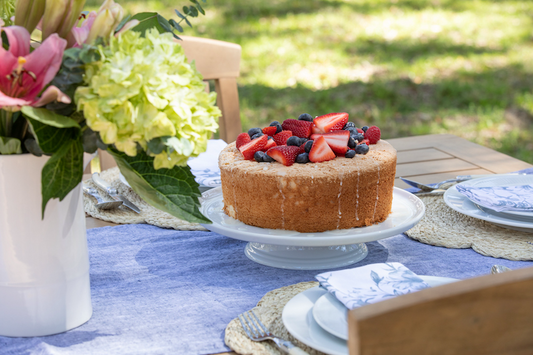 Ina Garten's Lemon Angel Food Cake on a cake stand with lemon glaze