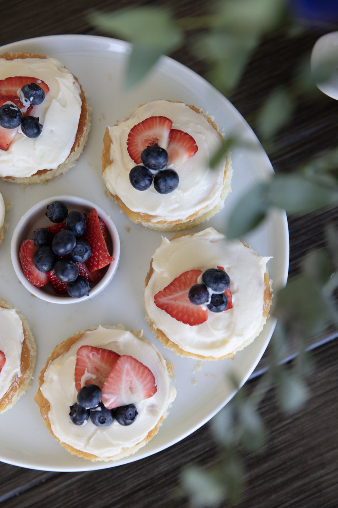 Classic yellow layer cake with lemon curd filling and fresh strawberries on a cake stand