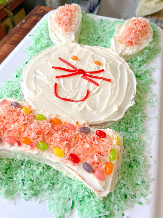 Family Easter bunny cake decorated through four decades of tradition on a cake stand
