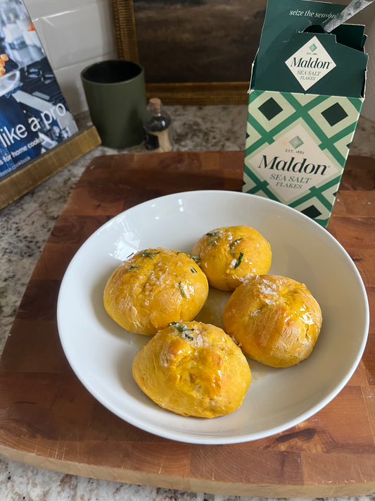 Homemade Pumpkin Rolls with Rosemary and Sea Salt on a baking sheet