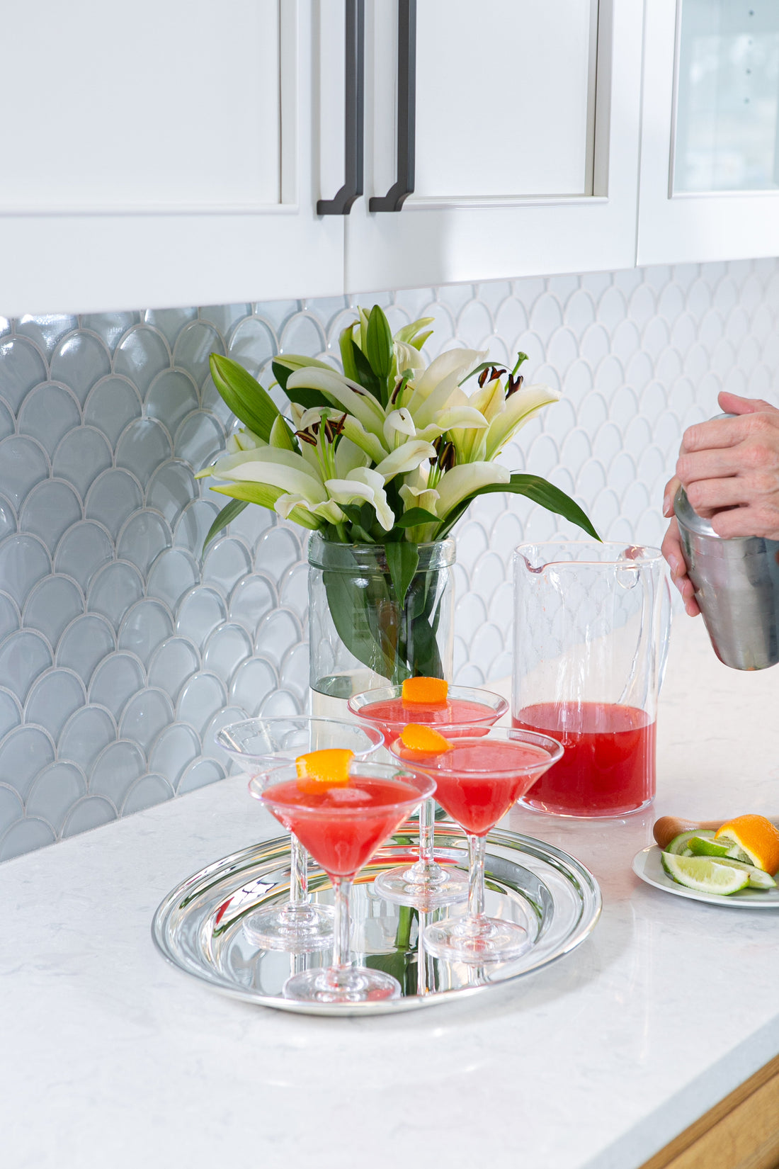 Ina Garten's Blood Orange Cosmos in martini glasses on a silver tray being garnished with orange twists