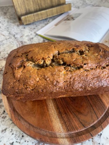 Ina Garten's Banana Bread loaf sliced on a wooden cutting board
