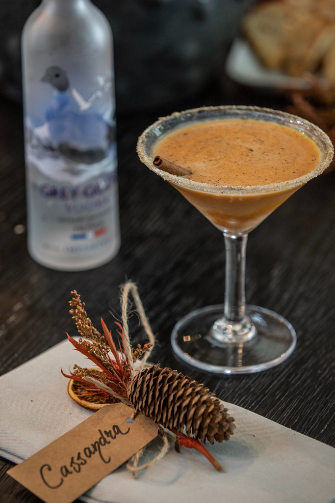Pumpkin Pie Martini with whipped cream and cinnamon spice garnish in a coupe glass