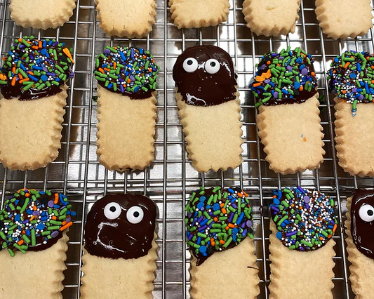 Ina Garten's Halloween shortbread cookies with chocolate icing and sprinkle faces on a cooling rack