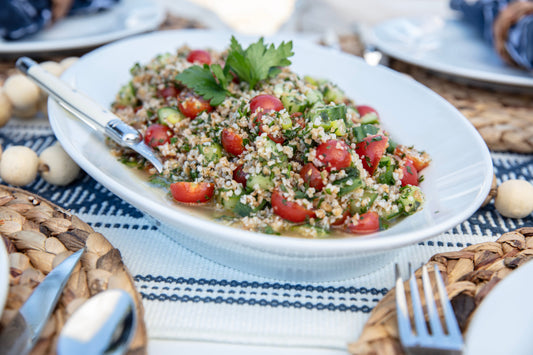 Ina Garten's Quinoa Tabbouleh with Feta, cherry tomatoes, cucumber, and herbs on a white oval plate