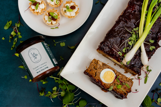 Tomato Conserve Meatloaf wrapped in bacon by The Southern Conserve on a serving platter