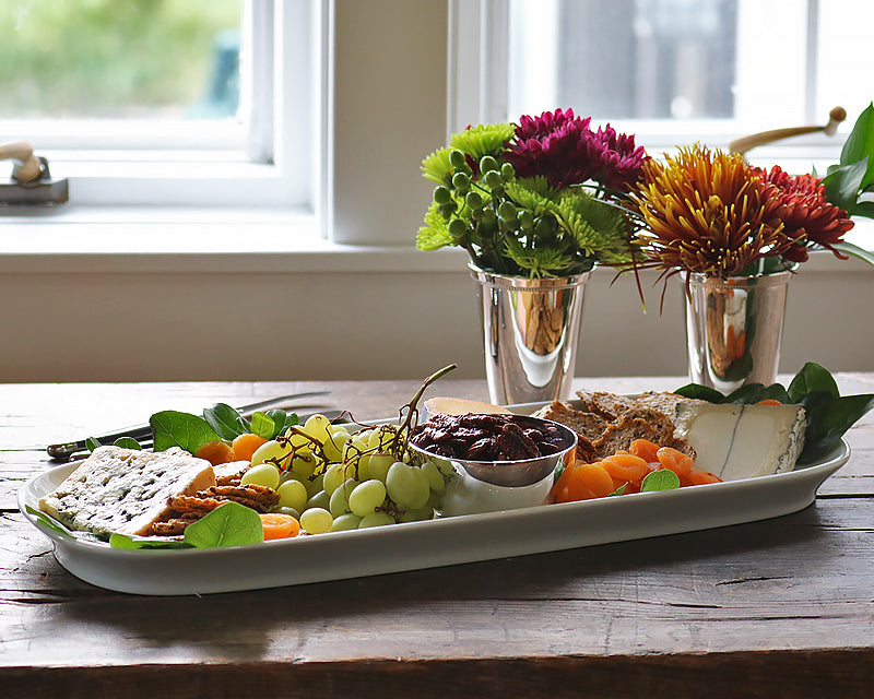 The Barn Platter sits on a wood table next to Hotel Silver mint julep cups filled with fall flowers
