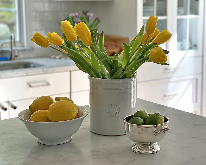 Classic Footed Bowl filled with lemons on a marble counter. A great bowl for keeping fruit handy on the counter. 