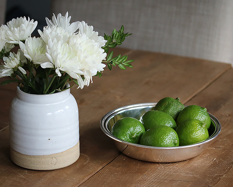 8-inch Hotel Silver Round Dish on a wood table filled with limes.