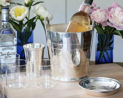 Hotel Silver Wine cooler on a bar table filled with simple clear glassware and beautiful floral arrangements.