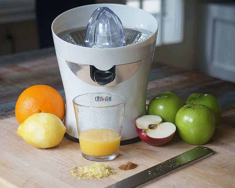 all-citrus juicer on table surrounded by fruit